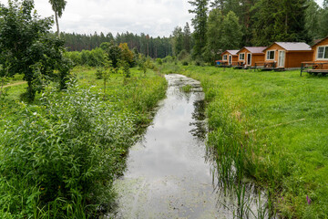 Cabins nestled along a peaceful stream with vibrant foliage
