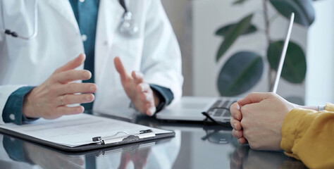 Doctor and patient consultation in clinic. Patient listens attentively as a doctor explains a...