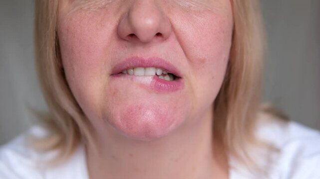 bite lower lip Headshot of frustrated stressed Caucasian woman biting lower lip and frowning, feeling nervous and anxious while receiving unsettling negative news. Body language