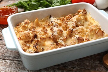 Tasty baked cauliflower on wooden table, closeup