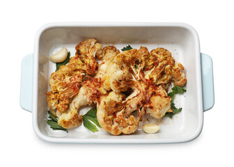 Delicious baked cauliflower steaks with garlic and parsley in baking dish isolated on white, top view