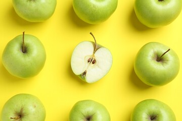 Flat lay composition with half of apple surrounded by ones on yellow background