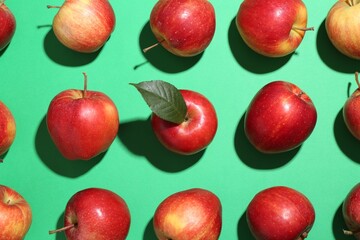 Red apples on green background, flat lay