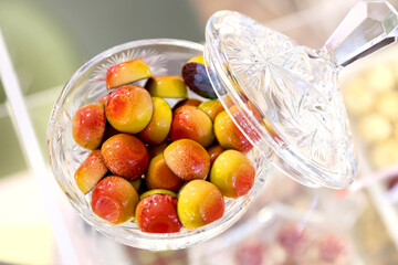 Closeup of colored handmade chocolate candies filled with orange and mango cream.