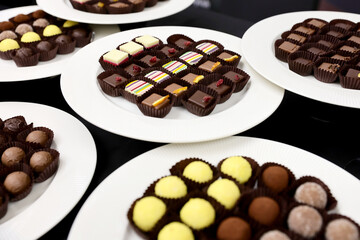 Colored handmade chocolate candies on a plate.