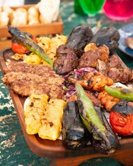 Mixed grill platter being served on wooden board