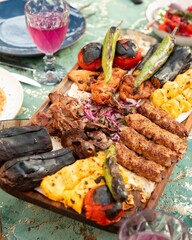 Assorted grilled meat and vegetables platter being served on restaurant table