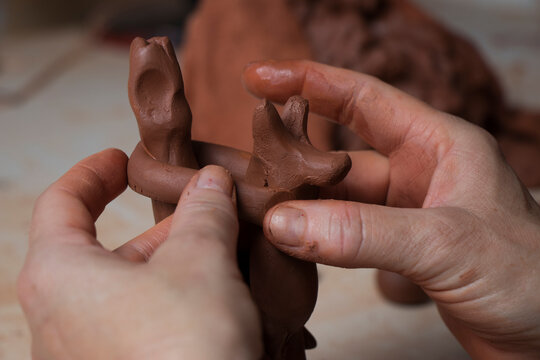 The hands of a craftswoman elaborating a traditional and ancestral figure of clay craftsmanship in Mallorca (Spain) called "siurell".