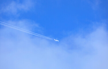 white trails colled contrails in the sky left by an airplane during a flight