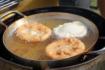three large fritters that are cooked in boiling oil during the village festival