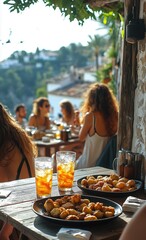Close-up of food and drinks on a terrace in a Mediterranean town, with blurred people in the background. Sunny day, blue sky, rustic and relaxed atmosphere.