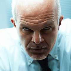 Businessman staring aggressively with menacing expression