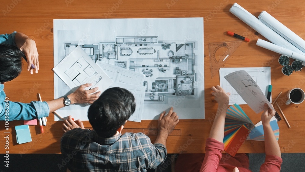 Poster group of people looking at blueprint while brainstorming idea. top view of engineer team looking and