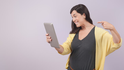 Woman pointing at a tablet and smiling