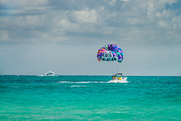Parachute with tourists being towed by a speedboat, in parasailing,  on the beach. South Beach, Miami, Florida, USA