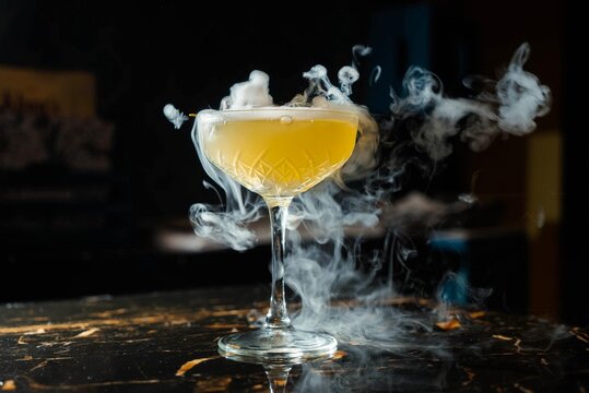 Delicious smokey vibrant yellow cocktail in an elegant glass