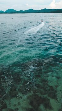 Vertical Video - Aerial Capture of Water Scooter Rides in Stunning Blue Waters