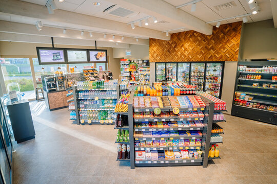  A modern convenience store with well-organized shelves displaying snacks, beverages, and groceries in a bright, spacious interior.