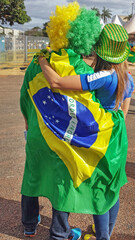 Couple of soccer fans with Brazil National Flag at National Stadium before the Soccer Game Brazil x...