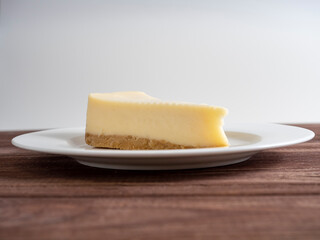 delicious cheesecake on a white plate. Wooden background, front view