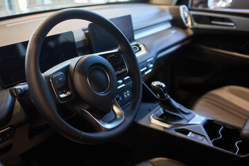 Closeup of a modern car steering wheel with control buttons for technology and convenience