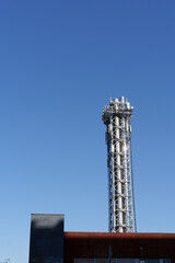 chimney in chrome for heating of a settlement on sky background