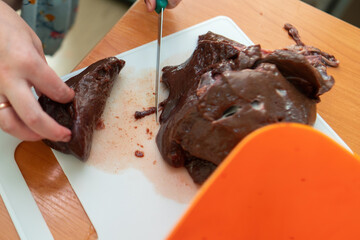 intricate process of slicing beef liver with a knife, highlighting the artistry and precision in culinary preparation, symbolizing nourishment and tradition