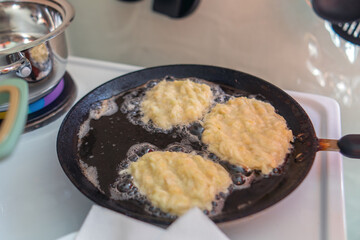 vibrant scene of zucchini fritters sizzling in a skillet, showcasing the golden-brown texture and inviting aroma of freshly cooked comfort food