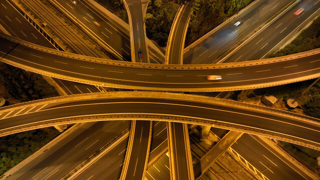 Aerial drone long exposure night shot of highway multilevel junction highway with light traffic leaving car headlights white and red trails