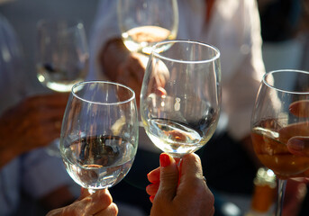 Obraz premium A group of people toast with crystal glasses with albariño wine, white wine