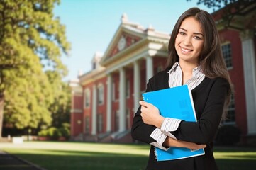 Fototapeta premium Happy young woman student outside at college.