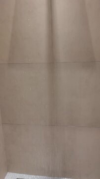 Shower Head with Water Flowing Down in Modern Bathroom