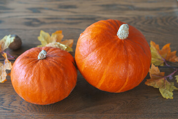 Orange pumpkins with autumn leaves on a wooden table. Halloween, Thanksgiving day holiday decor