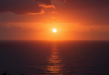 Obraz premium A stunning sunrise bathes the ocean in vibrant red light as clouds reflect the colors above. Waves gently lap the shore, creating a peaceful atmosphere at dawn. Humidity haze over water. Generative AI