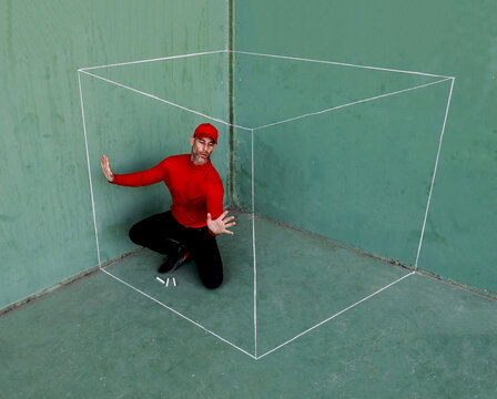Man inside an imaginary box in a green room