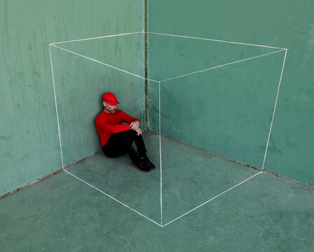 Man in red sitting inside an imaginary white box