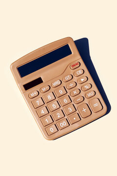Vintage golden calculator on a soft pale background