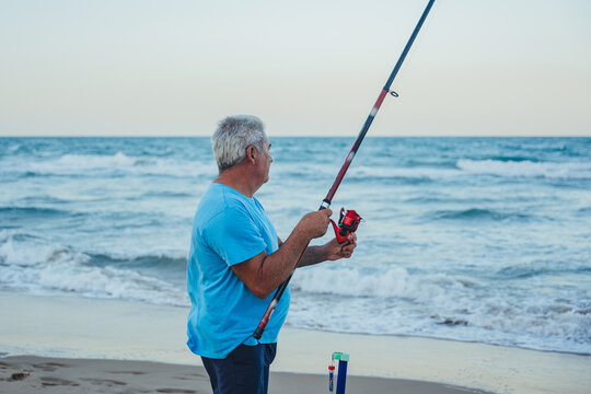 Elderly man fishing by the sea in Valencia, Spain