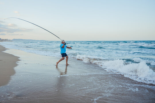 Senior fisherman engaging in beach fishing in Valencia, Spain