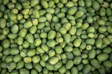 Green fresh olives on a stall for sale. Background.