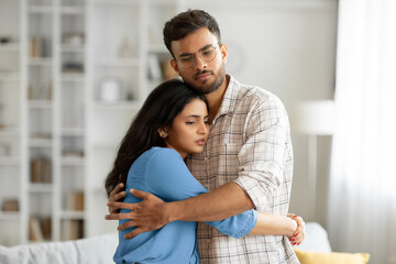 Loving indian man hugging, comforting and supporting his wife feeling sad and depressed, unhappy...