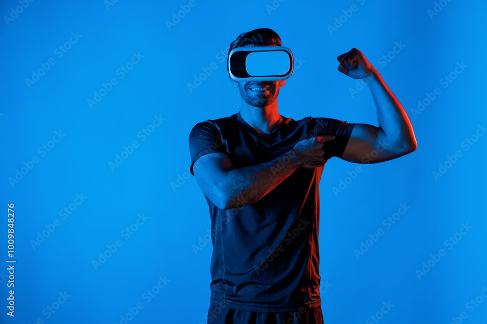 Poster happy man with vr goggle flexing muscle at neon light background. healthy person with casual cloth r