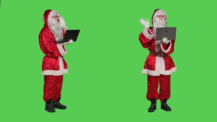 Saint nick waving at videocall on pc standing over full body greenscreen background, portraying...