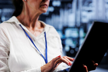 Knowleadgeable engineer using laptop, ensuring data remains shielded from potential security liabilities, safeguarding server room hardware against unauthorized access and vulnerabilities, close up