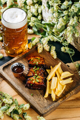 Beer with roasted ribs and French fries, perfect meal for a traditional pub or restaurant setting