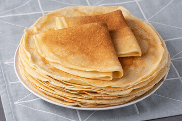 Stack of traditional russian pancakes blini on gray background. Homemade russian thin pancakes...