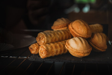 Tubes with condensed milk. A display case of a bakery or coffeeshop. Various types of mini desserts...
