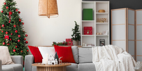 Interior of living room with sofas, Christmas trees and candle holders