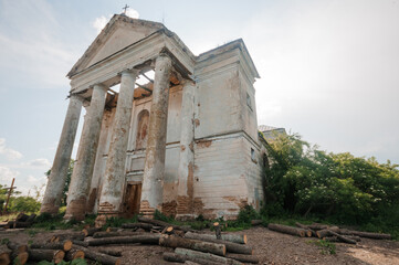Abandoned Church with Weathered Columns and Overgrown Surroundings