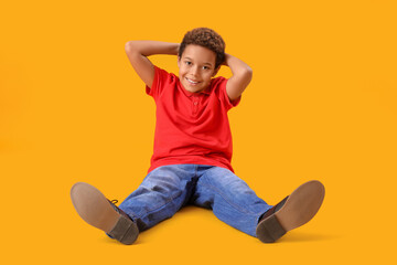 Little African-American boy on yellow background